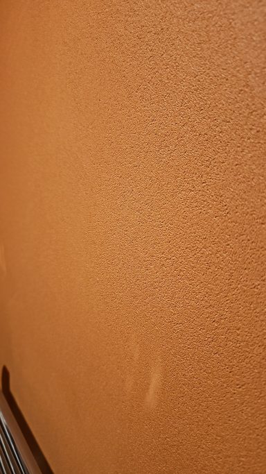 Close-up of warm terracotta microcement texture hand-applied in Norfolk